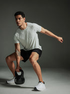 Man exercising with a kettlebell against a dark background