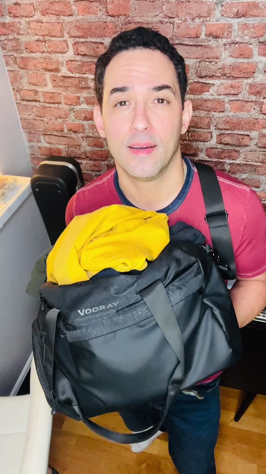 Man packing TechTee travel set into a travel bag, space-saving performance apparel for business travel